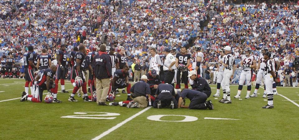 Players from both the Bills and Broncos watch as medical staff attend to tight end Kevin Everett.