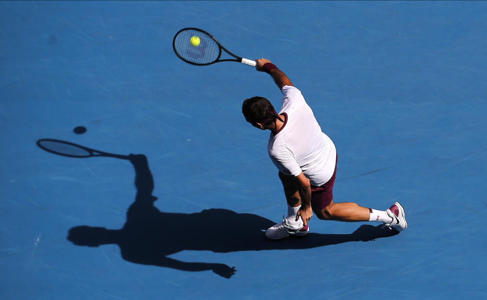 Switzerland's Roger Federer makes a backhand return to Tennys Sandgren of the U.S. during their quarterfinal match at the Australian Open tennis championship in Melbourne, Australia, Tuesday, Jan. 28, 2020. (AP Photo/Andy Wong)