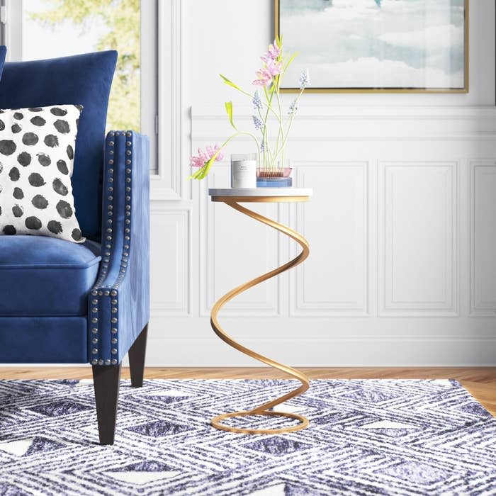 the end table with a marble top and curved base