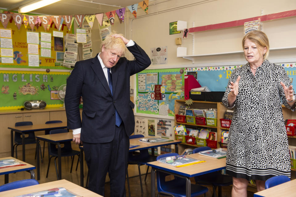 Britain's Prime Minister Boris Johnson talks to head teacher Bernadette Matthews during his visit to St Joseph's Catholic Primary School, London, Monday Aug. 10, 2020, to see the steps they are taking to be COVID secure ahead of children returning in September. (Lucy Young/Pool via AP)