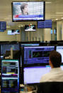 Traders watch television screens as they work at their desks whilst screens show market data at CMC Markets in London, Britain, January 16, 2019. REUTERS/John Sibley