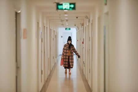 A girl carries a small dog in her bag as she walks inside a dormitory housing broadcasts of live streaming talent agency Three Minute TV in Beijing, China, February 11, 2017. Picture taken February 11, 2017. REUTERS/Damir Sagolj