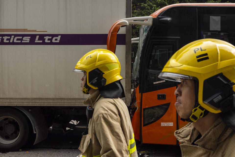 Rescue staff inspect after an accident on a highway in Hong Kong, Friday, March 24, 2023. Four passenger buses and a truck collided near a Hong Kong road tunnel Friday, injuring dozens of people. (AP Photo/Louise Delmotte)