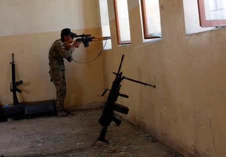 A member of Iraqi Army aims at Islamic State positions from a school building on the frontline during clashes in north west of Mosul, Iraq, May 8, 2017. REUTERS/Danish Siddiqui