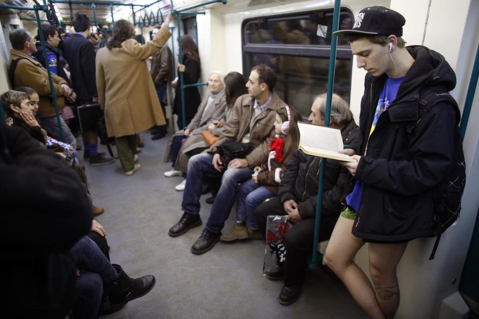 Passenger without his pants reads a book as he uses a subway train during the "No Pants Subway Ride" event in Sofia