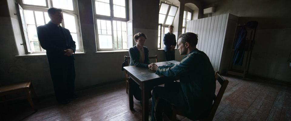 August Diehl as Franz Jägerstätter and Valerie Pachner as his wife, Franziska. Here she is visiting him in a Berlin jail, begging him to sign the papers to appeal his death sentence.