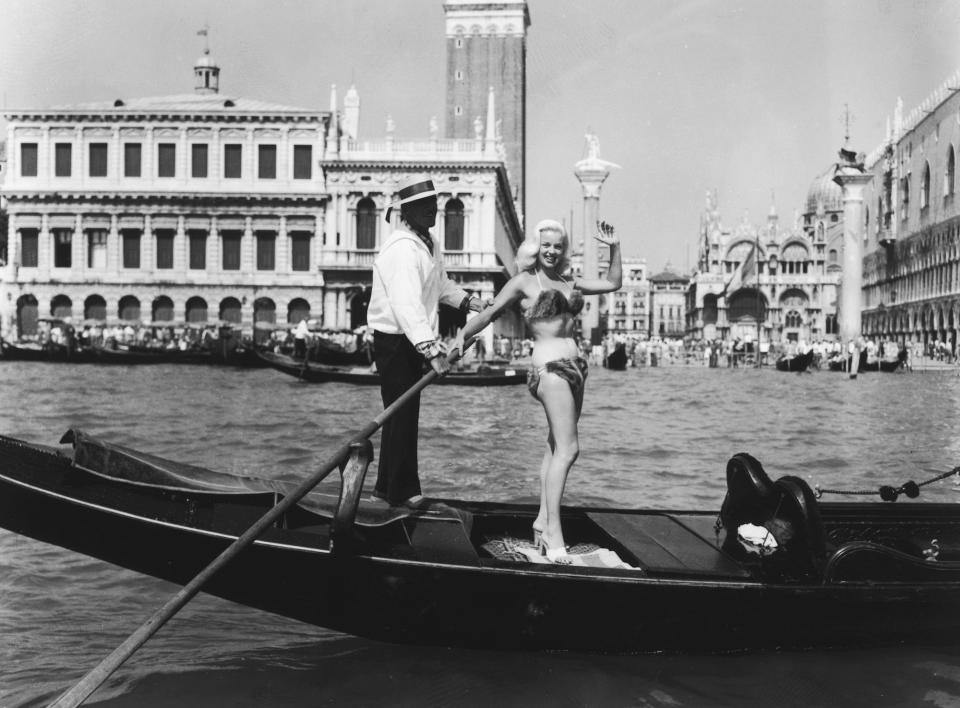 Actress Diana Dors arrives at the Venice Film Festival while wearing a fur bikini in 1955.