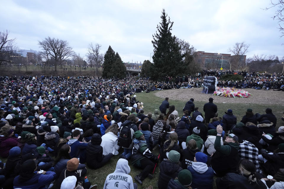 Mourners sit at The Rock on the grounds of Michigan State University in East Lansing, Mich., Wednesday, Feb. 15, 2023. Alexandria Verner, Brian Fraser and Arielle Anderson were killed and several other students remain in critical condition after a gunman opened fire on the campus of Michigan State University Monday night. (AP Photo/Paul Sancya)