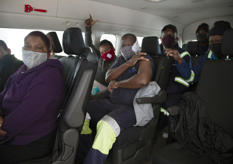 People sit in a minibus vehicle prior to be vaccinated, at the Houghton Mosque, which is being used as a drive-thru COVID-19 vaccination centre in Johannesburg Wednesday, July 28, 2021. Hitting its stride after a faltering start, South Africa’s mass vaccination campaign gave jabs to 220,000 people a day last week and is accelerating toward the goal of 300,000 per day. With large deliveries of doses arriving and some vaccines being assembled here, South Africa appears on track to inoculate about 35 million of its 60 million people by the end of the year. (AP Photo/Denis Farrell)