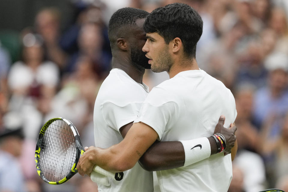 Spain's Carlos Alcaraz, right, embraces Francis Tiafoe of the United States following their third round match at the Wimbledon tennis championships in London, Friday, July 5, 2024. (AP Photo/Alberto Pezzali)