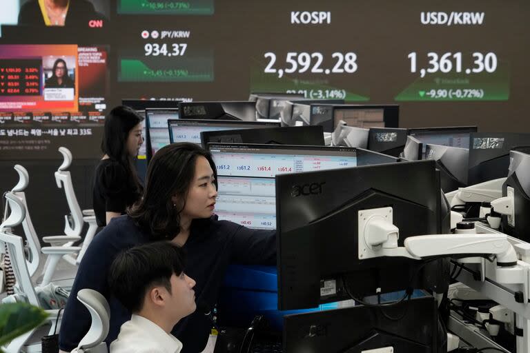 Corredores de divisas trabajan cerca de una pantalla que muestra el índice KOSPI surcoreano en la sede del banco KEB Hana, este lunes 5 de agosto de 2024, en Seúl, Corea del Sur