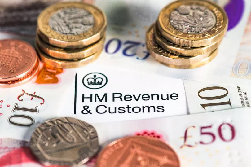 British banknotes surrounding the HM Revenue & Customs heading on a UK Government tax form.