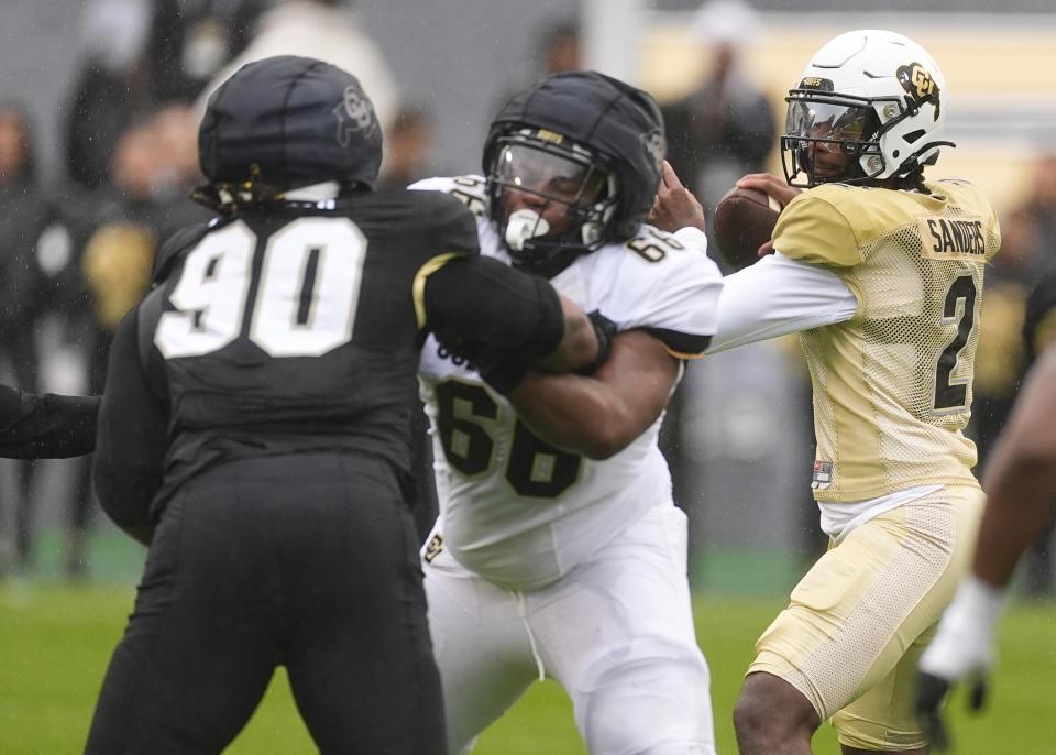 Colorado quarterback Shedeur Sanders, right, drops back to pass the ball as guard Justin Mayers, center, blocks defensive tackle Taurean Carter during the first half of the team's spring NCAA college football game, Saturday, April 27, 2024, in Boulder, Colo. (AP Photo/David Zalubowski)