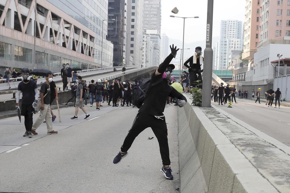 A protestor throws a block towards police as they clash during a protest in Hong Kong, Saturday, Aug. 24, 2019. Hong Kong protesters skirmished with police on Saturday as chaotic scenes returned to the summer-long protests for the first time in more than a week. (AP Photo/Kin Cheung)
