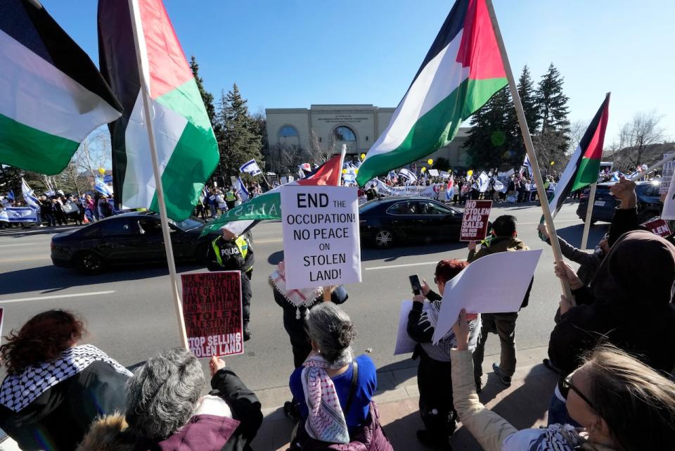 Pro-Palestine protesters wave flags facing a pro-Israel demonstration in front of a synagogue hosting "the Great Israeli Real Estate Event," in Thornhill, Ont., Thursday, March 7, 2024. THE CANADIAN PRESS/Frank Gunn