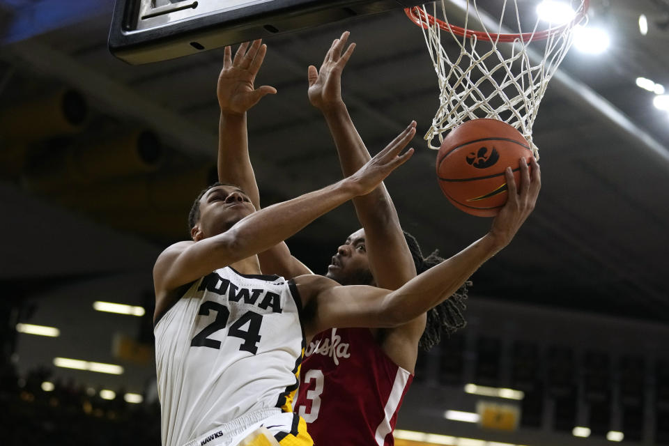 Iowa forward Kris Murray (24) drives to the basket past Nebraska forward Derrick Walker, right, during the second half of an NCAA college basketball game, Sunday, March 5, 2023, in Iowa City, Iowa. Nebraska won 81-77. (AP Photo/Charlie Neibergall)