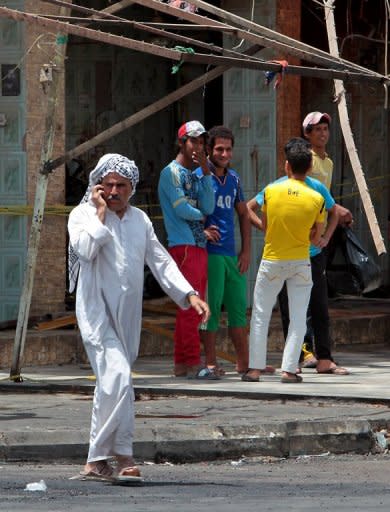 An Iraqi man walks past the site of a blast in Baghdad on Thursday. The day's deadliest attack struck in the north Baghdad neighbourhood of Shuala, where a car bomb killed at least 13 people and wounded 32, medical officials said