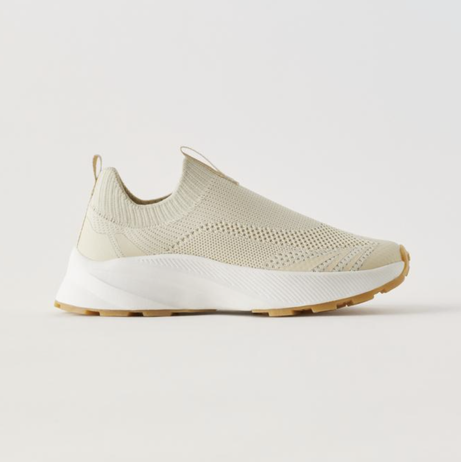 An off-white knit slip-on sneaker with a crisp white sole