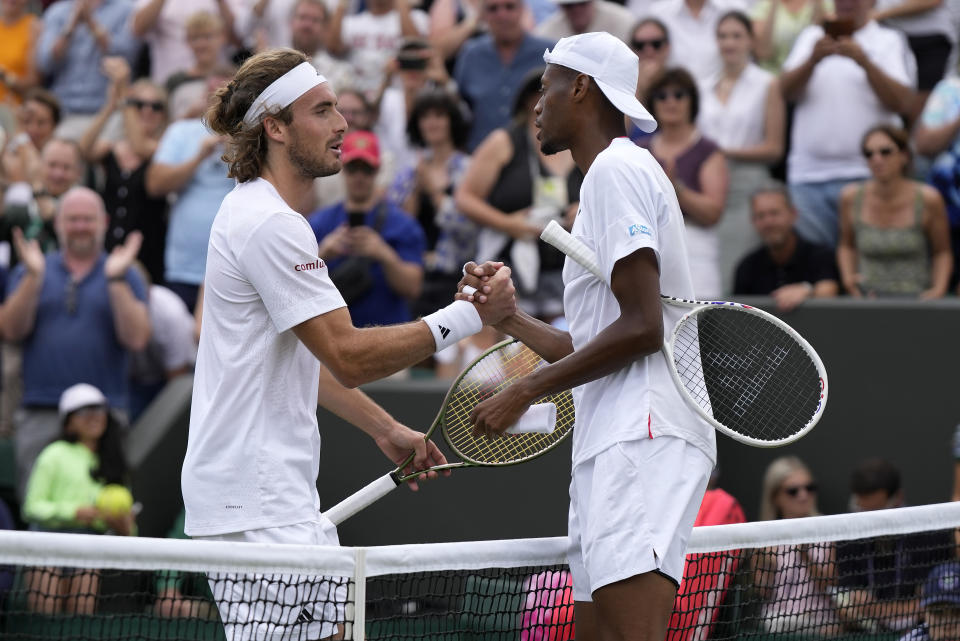 Christopher Eubanks of the US, right, greets Stefanos Tsitsipas of Greece at the net after beating him in a men's singles match on day eight of the Wimbledon tennis championships in London, Monday, July 10, 2023. (AP Photo/Alastair Grant)