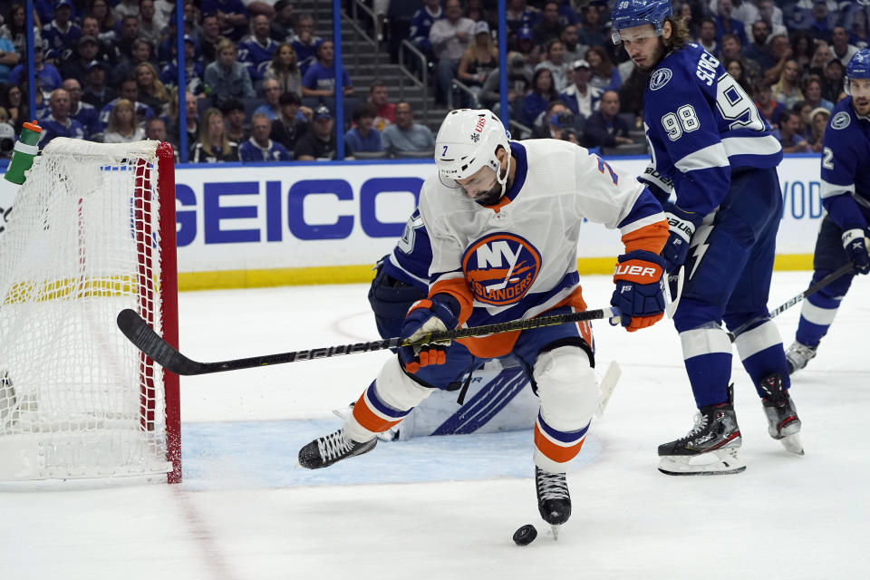 New York Islanders right wing Jordan Eberle, front, hits the puck with his foot in front of Tampa Bay Lightning defenseman Mikhail Sergachev (98) during the first period in Game 5 of an NHL hockey Stanley Cup semifinal playoff series Monday, June 21, 2021, in Tampa, Fla. (AP Photo/Chris O'Meara)