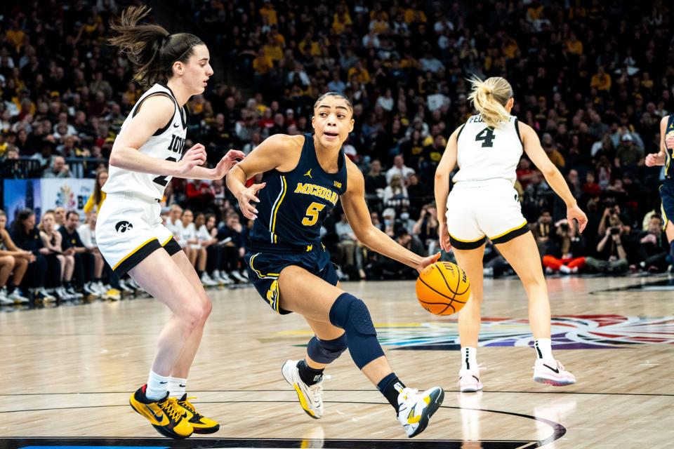 Michigan guard Laila Phelia (5) drives to the basket Iowa guard Caitlin Clark (22) during the Big Ten Tournament semifinals at the Target Center on Saturday, March 9, 2024, in Minneapolis, Minn.