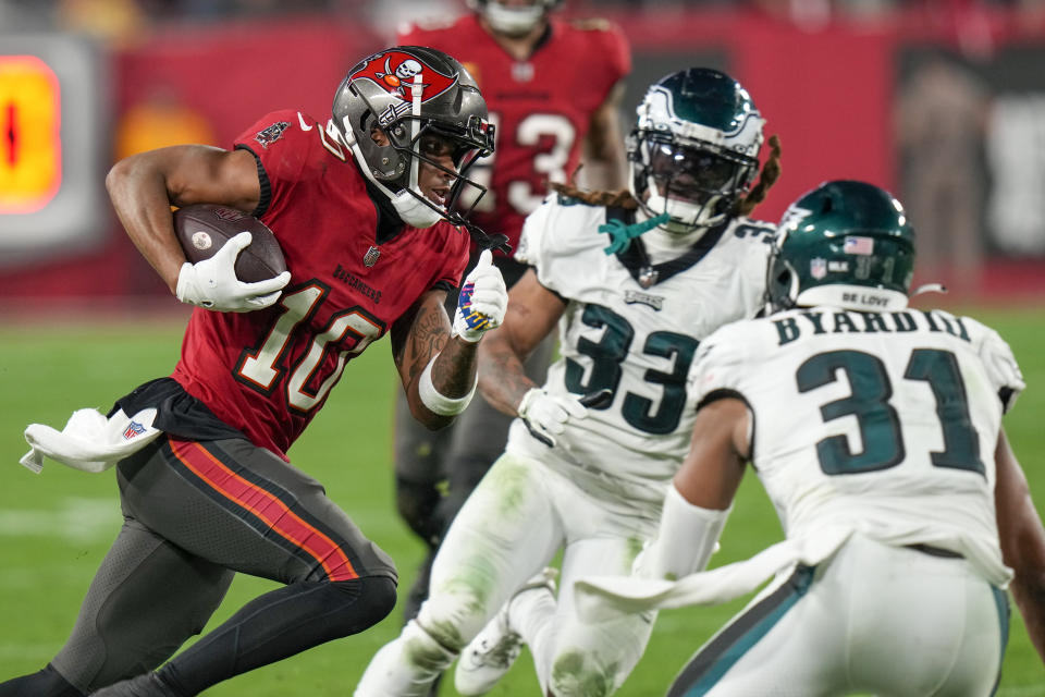 Tampa Bay Buccaneers wide receiver Trey Palmer (10) runs for a touchdown after making a catch as Philadelphia Eagles cornerback Bradley Roby (33) and safety Kevin Byard (31) attempt to tackle him during the second half of an NFL wild-card playoff football game, Monday, Jan. 15, 2024, in Tampa, Fla. (AP Photo/Chris O'Meara)