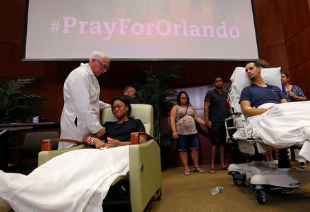 Gunshot survivor Patience Carter (2nd L) is comforted by Dr. Neil Finkler as fellow survivor Angel Santiago (R) looks on at a news conference at Florida Hospital Orlando on the shooting at the Pulse gay nightclub in Orlando, Florida, U.S., June 14, 2016. REUTERS/Jim Young/File Photo