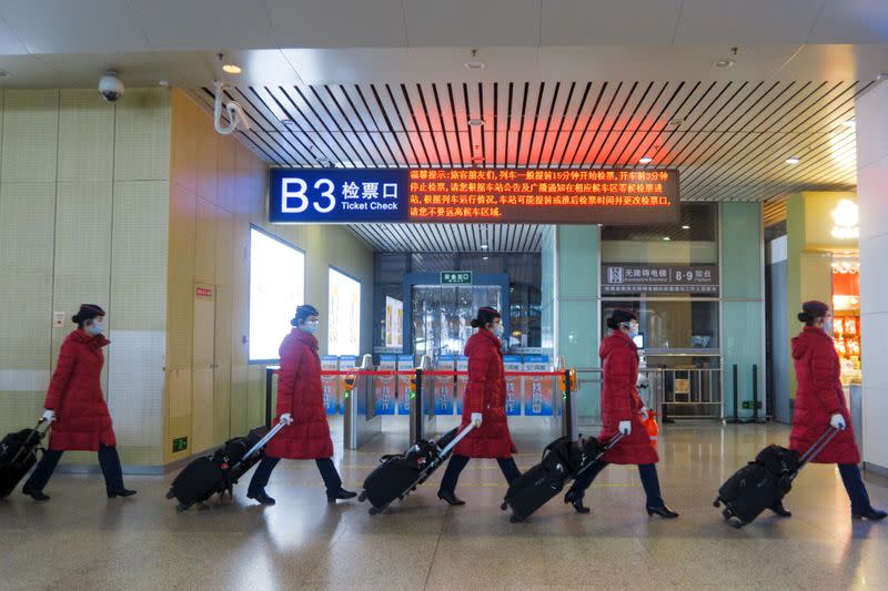 FILE PHOTO:Train attendants walk in Wuhan Railway Station following an outbreak of the coronavirus disease (COVID-19) in Wuhan