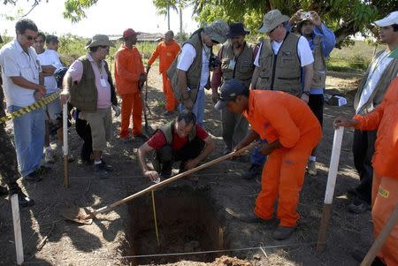 Forensic experts monitor as workers dig a hole in search of the remains of members of the Araguaia Guerrilla group killed in the 1970s during Brazil's last military dictatorship, in Tobacao, Para State, in this August 16, 2009 file photo. REUTERS/Paulo Santos