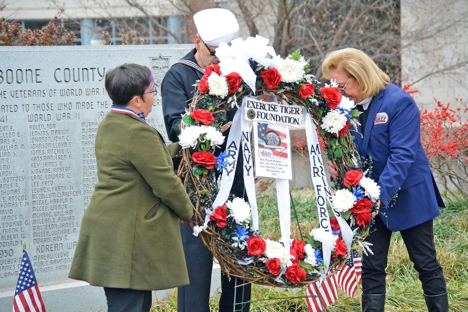 Columbia Mayor Barbara Buffaloe, from left, retired U.S. Navy Petty Officer Vladimir Chernov and Susan Haines, executive director of the U.S. Exercise Tiger Foundation place a memorial wreath Dec. 7, 2022 at the World War II and Korean War memorial at the Boone County Courthouse Square during a ceremony recognizing the 81st anniversary of the attack at Pearl Harbor.