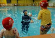 Australian muslim swimming instructor Fadila Chafic wears her full-length 'burkini' swimsuit during a swimming lesson with her children Taaleen (L) and Ibrahim at swimming pool in Sydney, August 23, 2016. REUTERS/Jason Reed