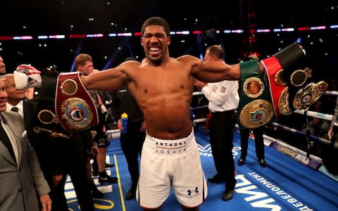 Anthony Joshua celebrates with his belts - Credit: getty images