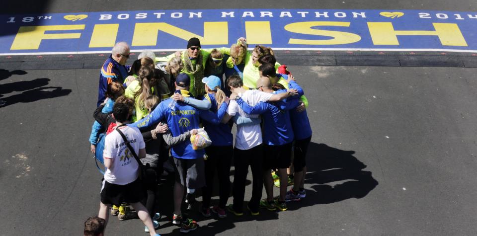 Boston Marathon bombing survivors, family and friends gather in circle after crossing the finish line of the marathon during a Tribute Run, Saturday, April 19, 2014, in Boston. The 118th Boston Marathon is scheduled to run on Patriots Day, Monday, April 21. (AP Photo/Charles Krupa)