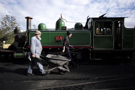Puffing Billy railway workers carry a wheelbarrow full of ash after cleaning out the smokebox of locomotive 6A at Belgrave station near Melbourne, October 17, 2014. REUTERS/Jason Reed