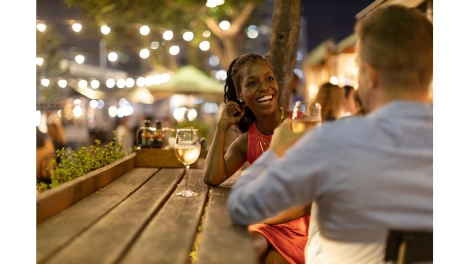 Couple drinking wine together outdoors at night