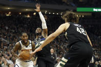 Denver Nuggets' Will Barton, left, drives to the basket against Milwaukee Bucks' Wesley Matthews, middle, and Robin Lopez (42) during the first half of an NBA basketball game Friday, Jan. 31, 2020, in Milwaukee. (AP Photo/Aaron Gash)