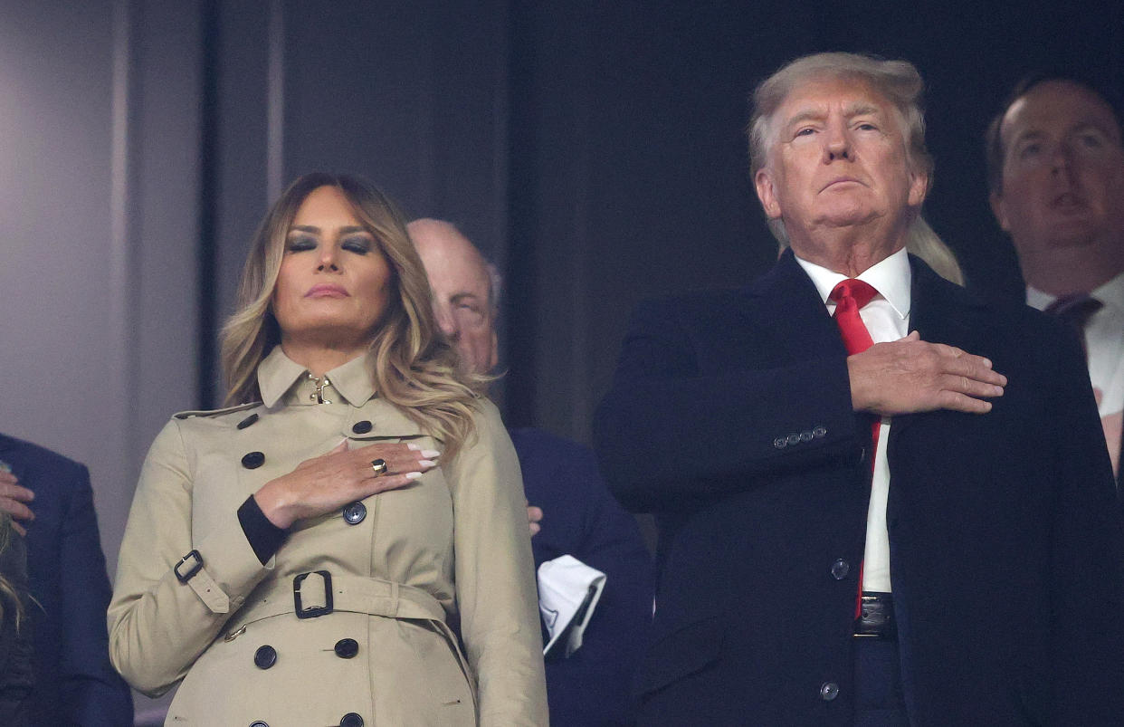 ATLANTA, GEORGIA - OCTOBER 30:  Former first lady and president of the United States Melania and Donald Trump stand for the national anthem prior to Game Four of the World Series between the Houston Astros and the Atlanta Braves Truist Park on October 30, 2021 in Atlanta, Georgia. (Photo by Elsa/Getty Images)