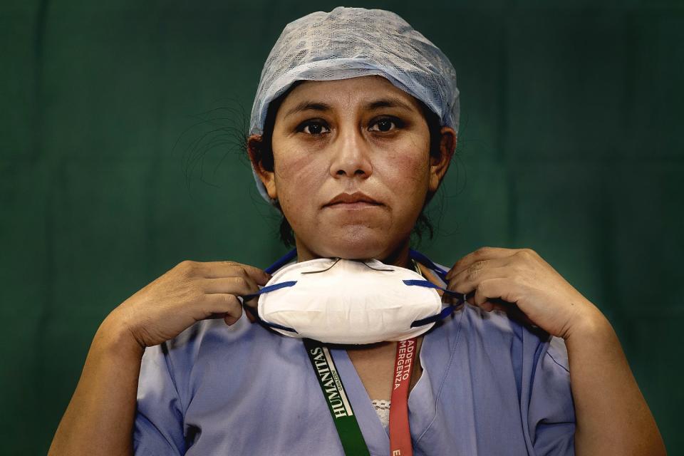 ITALY: Ana Travezano, 39, a nurse at the Humanitas Gavazzeni Hospital in Bergamo, removes her mask at the end of her shift on March 27.