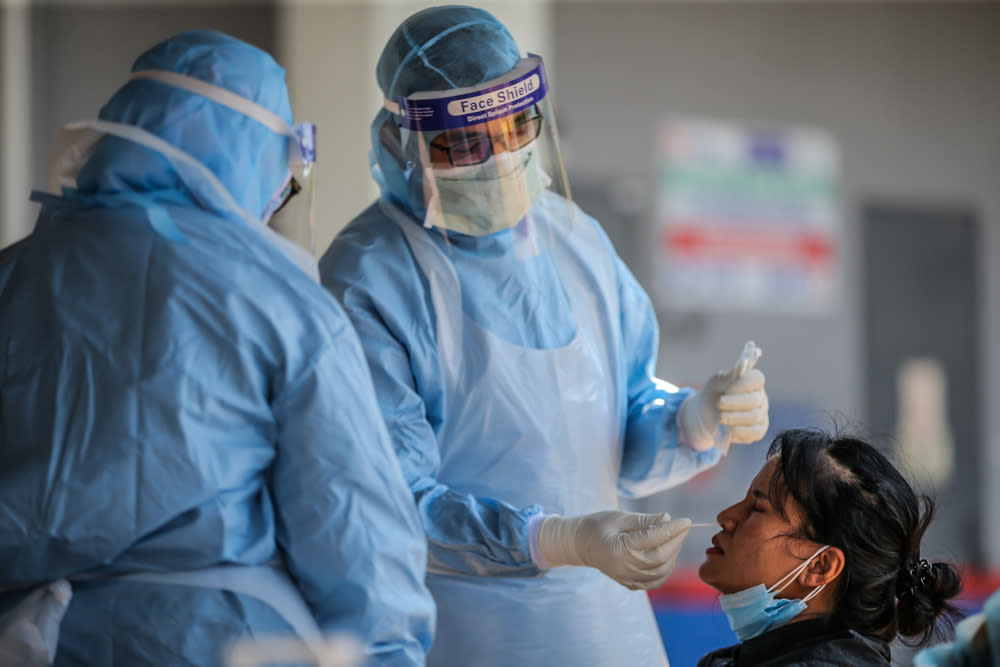 A medical worker takes a swab at a Covid-19 drive-through screening area at KPJ Ampang Puteri April 9, 2020. — Picture by Hari Anggara