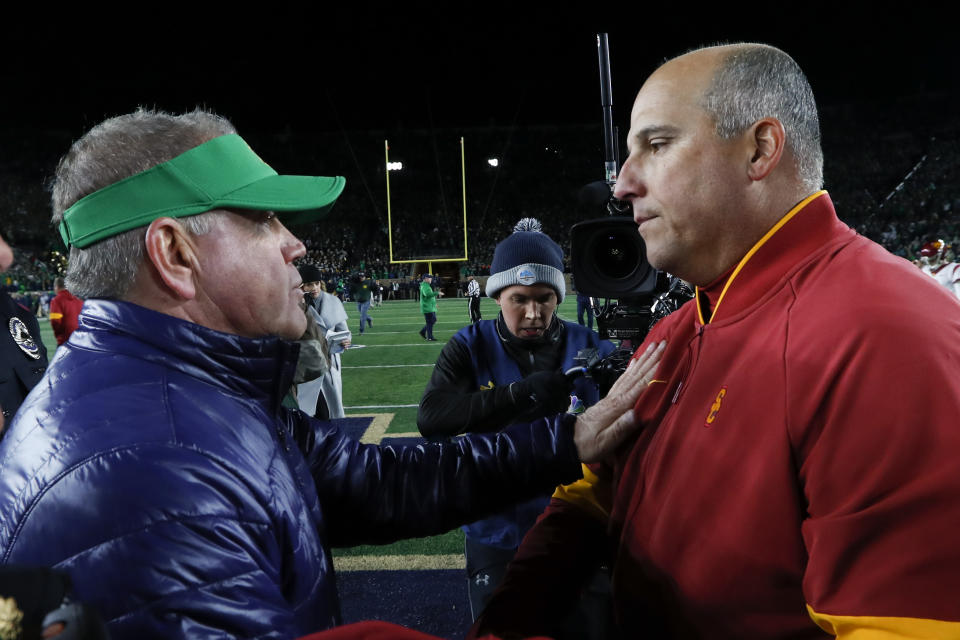 Notre Dame head coach Brian Kelly, left, and Southern California head coach Clay Helton meet after an NCAA college football game in South Bend, Ind., Saturday, Oct. 12, 2019. (AP Photo/Paul Sancya)