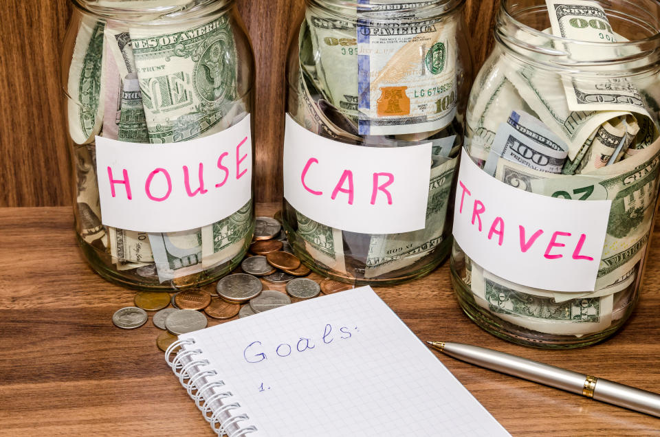 finance idea - new years resolutions with dollar in glass jar, coins on wooden table