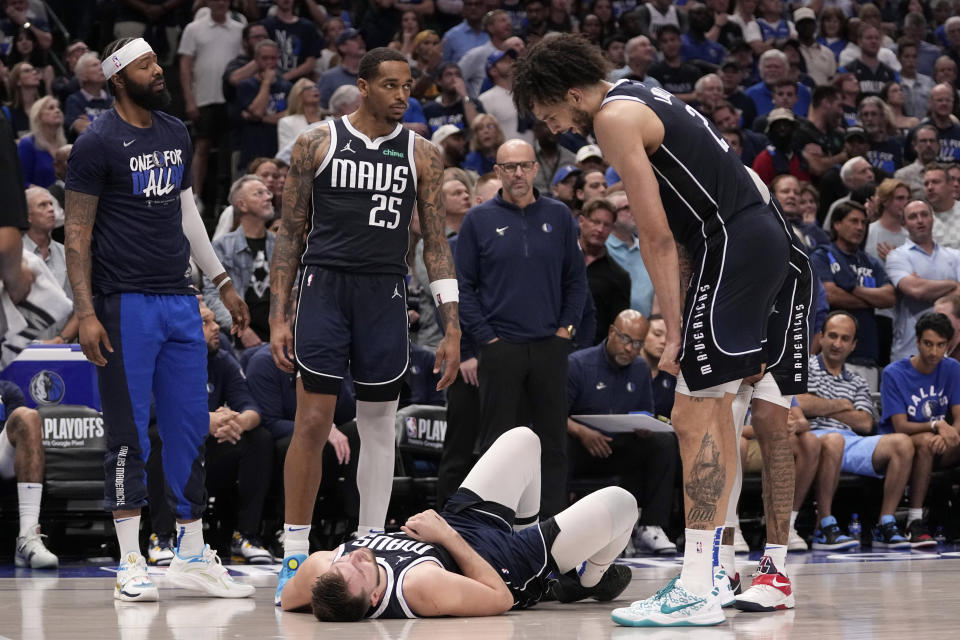 Dallas Mavericks' Markieff Morris, left, P.J. Washington (25), head coach Jason Kidd, center rear, and Dereck Lively II, right, look toward Luka Doncic, bottom, after Doncic and Oklahoma City Thunder' Luguentz Dort collided competing for a loose ball during the second half in Game 3 of an NBA basketball second-round playoff series, Saturday, May 11, 2024, in Dallas. (AP Photo/Tony Gutierrez)