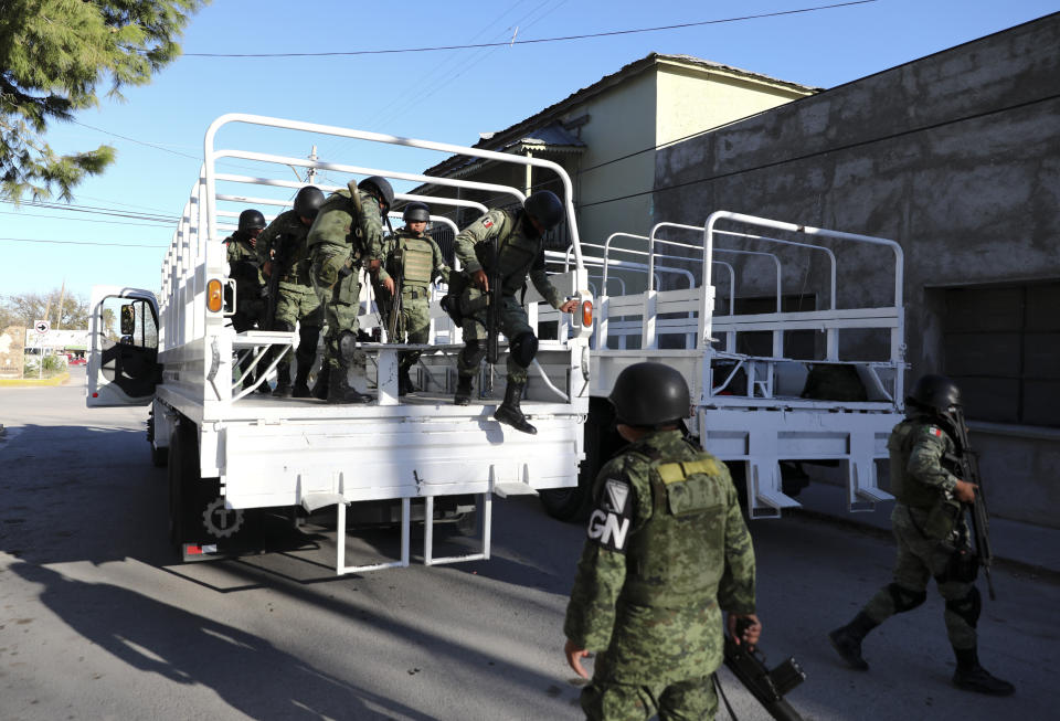 National Guard soldiers arrive in Villa Union, Mexico, Monday, Dec. 2, 2019. The small town near the U.S.-Mexico border began cleaning up Monday even as fear persisted after 22 people were killed in a weekend gun battle between a heavily armed drug cartel assault group and security forces. (AP Photo/Eduardo Verdugo)