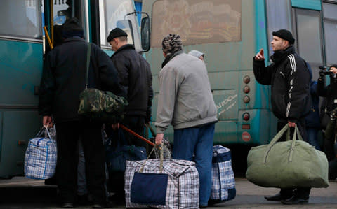 Prisoners of war board a bus during the exchange - Credit:  VALENTYN OGIRENKO/ REUTERS