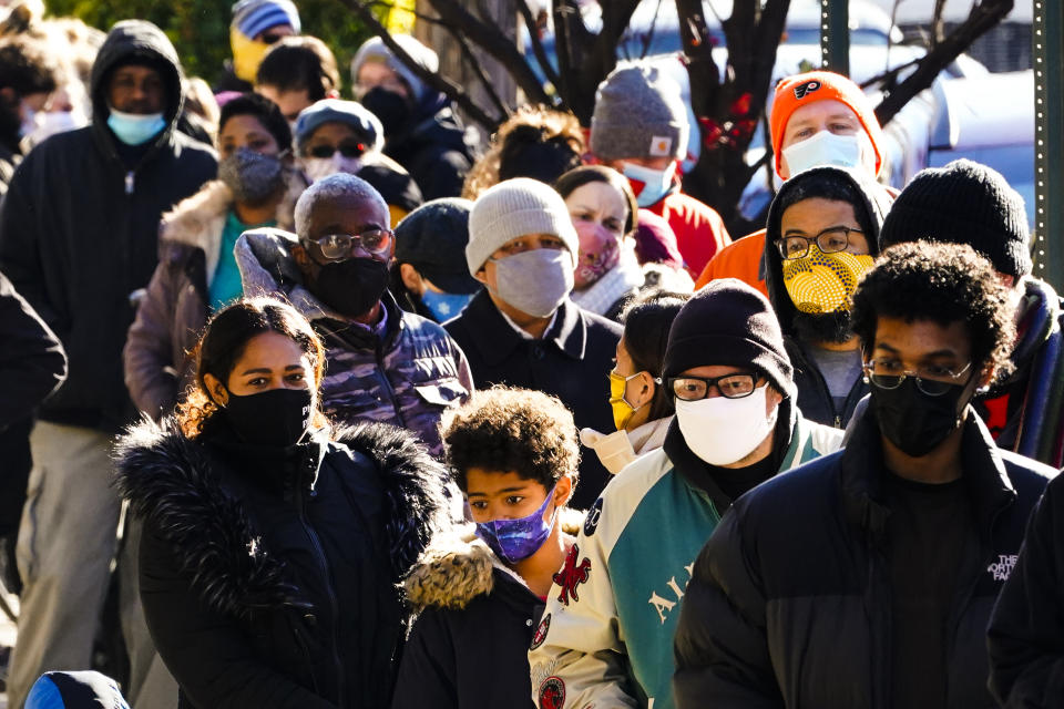 FILE -City residents wait in a line extending around the block to receive free at-home rapid COVID-19 test kits in Philadelphia, Monday, Dec. 20, 2021. Philadelphia is ending its indoor mask mandate, city health officials said Thursday night, April 21, 2022, abruptly reversing course just days after city residents had to start wearing masks again amid a sharp increase in infections.(AP Photo/Matt Rourke, File)