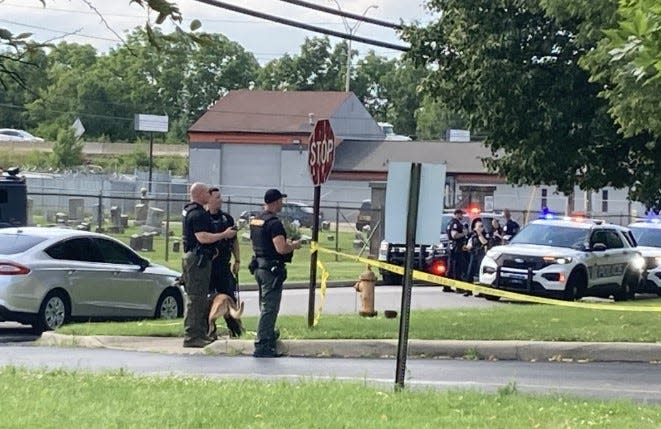 Law enforcement officers from Columbus police, the Franklin County Sheriff's Office and other departments in the area of the Franklin County Children's Services building across from Mount Calvary Cemetery. Two of three suspects involved in a crime spree and shooting of a Columbus police officer fled the scene Thursday and remain at-large. The other suspect was fatally shot by police on the interstate.