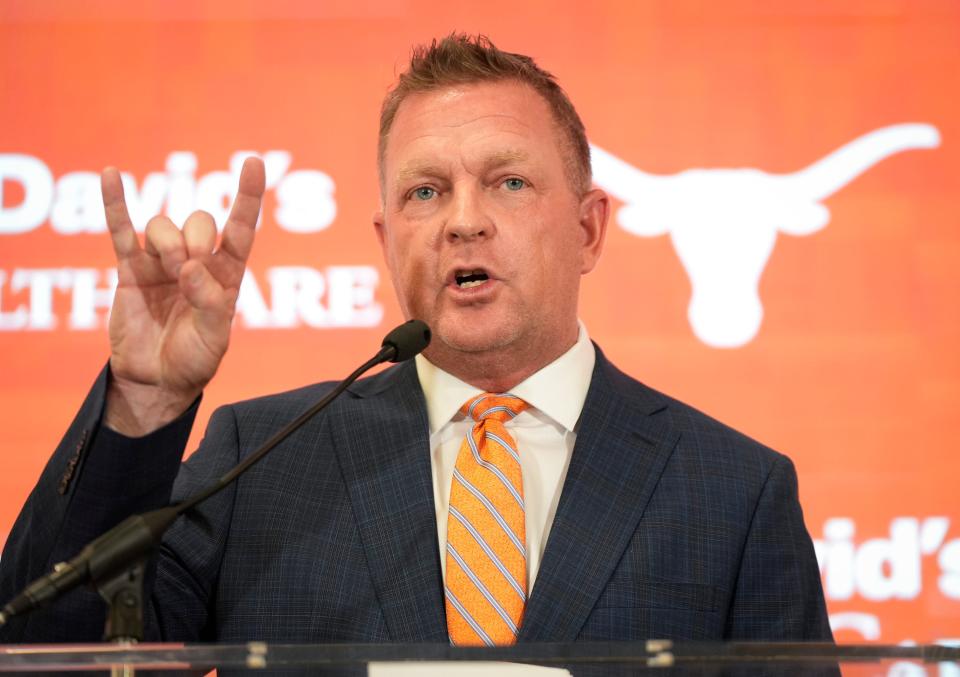 New Texas baseball coach Jim Schlossnagle flashes his Hook 'em sign during Wednesday's introductory press conference. He might be the first coach in history to flash a Gig 'em and a Hook 'em within a 24-hour period. Texas hired him away from rival Texas A&M.