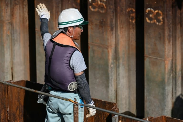 Un ouvrier porte une veste équipée de ventilateurs à piles dans la doublure, pour lutter contre la canicule, le 4 août 20223 à Tokyo (AFP - Richard A. Brooks)
