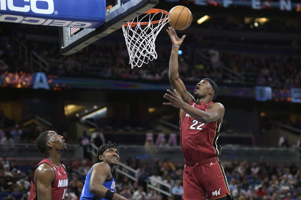 Miami Heat forward Jimmy Butler (22) goes up for a basket in front of Orlando Magic center Wendell Carter Jr., center, and Heat center Bam Adebayo, left, during the first half of an NBA basketball game, Saturday, March 11, 2023, in Orlando, Fla. (AP Photo/Phelan M. Ebenhack)