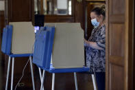 Voter Christina Tremblay of Providence, R.I., stands at a voting booth, Tuesday, June 2, 2020, at a voting station, in Providence. In-person voting is being offered at a reduced number of locations for voters who missed the deadline to request a mail ballot. (AP Photo/Steven Senne)